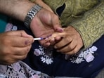 Kashmir, India - September. 21, 2024: An election officer applies indelible ink mark on the finger of Bibi, 87, before casting her vote from home, as the Election Commission of India (ECI) initiated a home voting facility for the elderly in the ongoing Jammu and Kashmir  Assembly elections in Srinagar,on September 21,2024.(Photo By Waseem Andrabi /Hindustan Times)--
