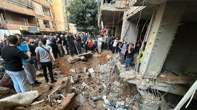People check the damage at the scene of an Israeli strike in Beirut's southern suburbs on September 20, 2024. (AFP)