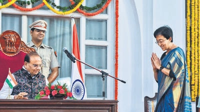 Lieutenant governor VK Saxena and Aam Aadmi Party leader Atishi during her swearing-in ceremony as the chief minister of Delhi on Saturday. (ANI) Lieutenant governor VK Saxena and Aam Aadmi Party leader Atishi during her swearing-in ceremony as the chief minister of Delhi on Saturday. (ANI)