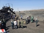 Miners and police officers gather around the site of a coal mine where methane leak sparked an explosion on Saturday, in Tabas, some 335 miles (540 kilometers) southeast of the capital Tehran, Iran, Sunday, Sept. 22, 2024.