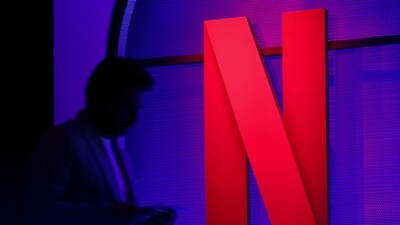 A man stands next to a logo of Netflix during an event in Mumbai, India. (Reuters)