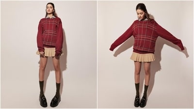 Embracing the demure academia aesthetic, Ananya wore an oversized red sweater featuring a colourful check print on the front. She styled it with a blue pinstriped button-down shirt and a beige mini skirt featuring a pleated silhouette. Embracing the demure academia aesthetic, Ananya wore an oversized red sweater featuring a colourful check print on the front. She styled it with a blue pinstriped button-down shirt and a beige mini skirt featuring a pleated silhouette. 