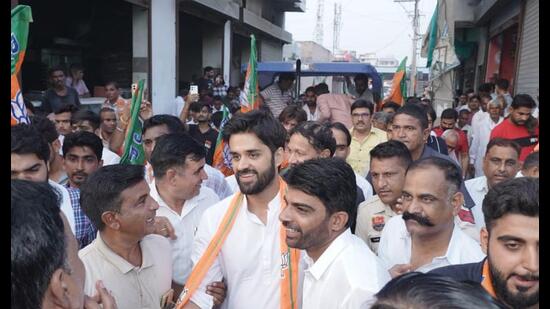 BJP’s Bhavya Bishnoi with supporters during electioneering in the Adampur assembly constituency.