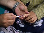 An election officer applies indelible ink on the finger of a woman in the ongoing Jammu and Kashmir assembly polls.(Waseem Andrabi/ HT Photo)