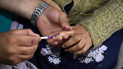 An election officer applies indelible ink on the finger of a woman in the ongoing Jammu and Kashmir assembly polls.(Waseem Andrabi/ HT Photo)