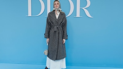 Elizabeth Debicki is a picture of elegance at the Dior show in a grey satin maxi skirt styled with a grey wool trench coat, a printed headscarf, embellished black pumps, and a mini clutch. (AFP) Elizabeth Debicki is a picture of elegance at the Dior show in a grey satin maxi skirt styled with a grey wool trench coat, a printed headscarf, embellished black pumps, and a mini clutch. (AFP)