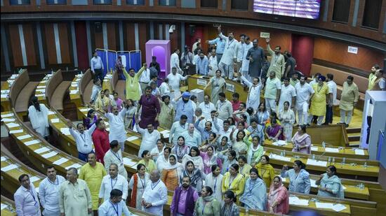 Councillors of the BJP and AAP raise slogans against one another over an impasse on mobile phones being allowed in the chamber. (PTI)