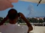 A man watches as smoke billows over southern Lebanon following an Israeli strike, amid ongoing cross-border hostilities between Hezbollah and Israeli forces.