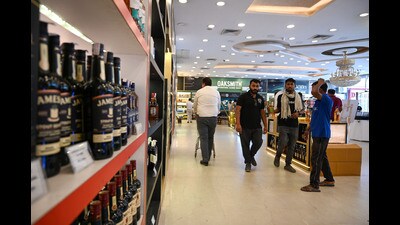 People buy liquor at a shop on MG Road near Sikandarpur Metro station in Gurugram on Friday. (HT PHOTO)