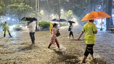 People cross the road while holding umbrellas amid rainfall in Mumbai where heavy rainfall caused waterlogging. (ANI Photo)