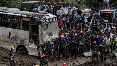 People stranded at the Tribhuwan Highway look on as rescue personnel work to retrieve the bodies of the victims from a landslide triggered by heavy rainfall in Dhading, Nepal, September 29, 2024. (Reuters)