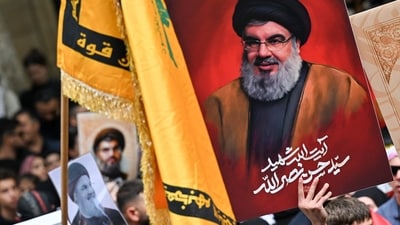 Demonstrators hold flags and pictures of Hassan Nasrallah, late leader of the Lebanese group Hezbollah, at a protest rally. (AFP) Demonstrators hold flags and pictures of Hassan Nasrallah, late leader of the Lebanese group Hezbollah, at a protest rally. (AFP)