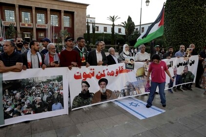 A young girl steps on an Israeli flag as demonstrators deploy a banner bearing pictures of slain Lebanese and Palestinian leaders. (AFP) A young girl steps on an Israeli flag as demonstrators deploy a banner bearing pictures of slain Lebanese and Palestinian leaders. (AFP)