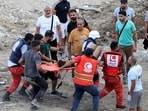 Rescue workers carry a man who was injured after an Israeli airstrike hit two adjacent buildings in Lebanon. Rescue workers carry a man who was injured after an Israeli airstrike hit two adjacent buildings in Lebanon.
