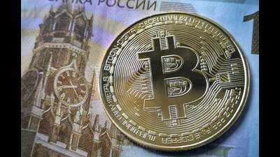 A souvenir bitcoin token is seen pictured with a 100 ruble bill in Moscow on July 30, 2024. Russian lawmakers voted on July 30, 2024 to tighten rules on petrocurrency mining, while also paving the way for it to be used in cross-border payments as a means to skirt Western sanctions. (Photo by Alexander NEMENOV / AFP) (AFP) A souvenir bitcoin token is seen pictured with a 100 ruble bill in Moscow on July 30, 2024. Russian lawmakers voted on July 30, 2024 to tighten rules on petrocurrency mining, while also paving the way for it to be used in cross-border payments as a means to skirt Western sanctions. (Photo by Alexander NEMENOV / AFP) (AFP)