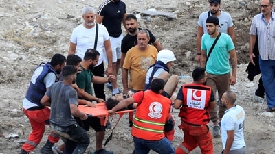 Rescue workers carry a man who was injured after an Israeli airstrike hit two adjacent buildings in Lebanon. (AP) Rescue workers carry a man who was injured after an Israeli airstrike hit two adjacent buildings in Lebanon. (AP)