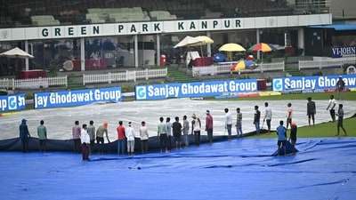 Groundsmen cover the field as rain delays the start of the second day play of the second Test cricket match between India and Bangladesh at the Green Park Cricket Stadium in Kanpur on September 28 (AFP)