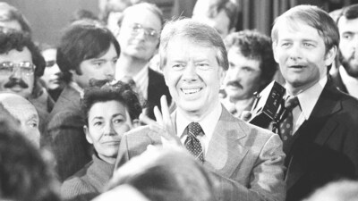 President Jimmy Carter, center, talks with reporters following his broadcast new conference, March 25, 1977, Washington.(AP Photo, File) (AP)