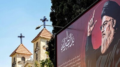 TOPSHOT - A drawing of Hassan Nasrallah, the slain leader of the Lebanese group Hezbollah who was killed days earlier in an Israeli air strike on Beirut's southern suburbs, is depicted next to a condolence message signed by Syria's President Bashar al-Assad on a billboard near a church in Damascus on October 1, 2024. (Photo by LOUAI BESHARA / AFP) (AFP) TOPSHOT - A drawing of Hassan Nasrallah, the slain leader of the Lebanese group Hezbollah who was killed days earlier in an Israeli air strike on Beirut's southern suburbs, is depicted next to a condolence message signed by Syria's President Bashar al-Assad on a billboard near a church in Damascus on October 1, 2024. (Photo by LOUAI BESHARA / AFP) (AFP)