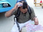 A supporter of climate activist Sonam Wangchuk shaves his head in front of Bawana police station.