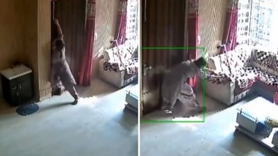 The image shows a woman using all her might to close a door to stop the robbers from entering her house. (Screengrab) The image shows a woman using all her might to close a door to stop the robbers from entering her house. (Screengrab)