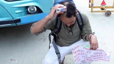 A supporter of climate activist Sonam Wangchuk shaves his head in front of Bawana police station.