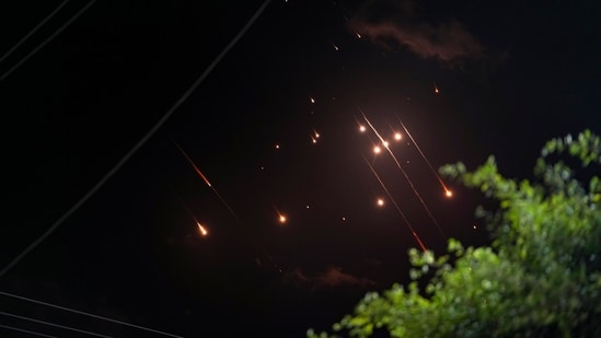 Missiles launched from Iran towards Israel streak across the night sky as seen from Deir al-Balah, Gaza Strip (AP)