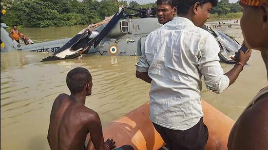 Locals assist in rescue operation after the IAF chopper made an emergency landing in a waterlogged area after developing a snag in Muzaffarpur district of Bihar on Wednesday. (PTI Photo)