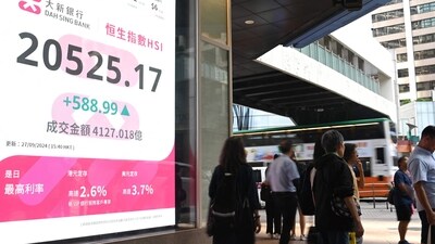 Pedestrians walk past a sign showing the numbers of the Hang Seng Index in Hong Kong. (AFP) Pedestrians walk past a sign showing the numbers of the Hang Seng Index in Hong Kong. (AFP)
