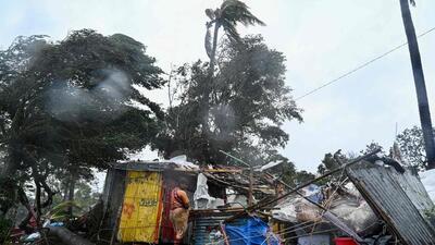 A woman stands next to her damaged house. (AFP) A woman stands next to her damaged house. (AFP)