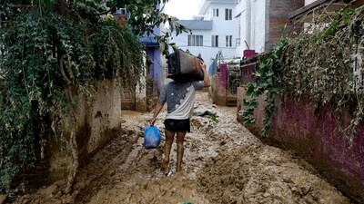 A man walks on a muddy alleyway carrying belongings salvaged from his house in Kathmandu, Nepal, Monday, Sept. 30, 2024 in the aftermath of a flood caused by heavy rains. (AP Photo/Gopen Rai) (AP) A man walks on a muddy alleyway carrying belongings salvaged from his house in Kathmandu, Nepal, Monday, Sept. 30, 2024 in the aftermath of a flood caused by heavy rains. (AP Photo/Gopen Rai) (AP)