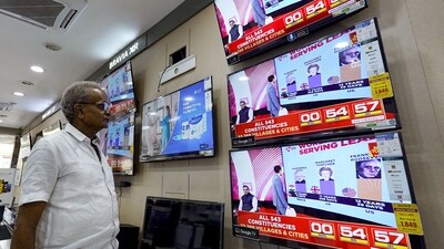 A man watching television waits for the release of exit polls published after voting concluded. (AFP)