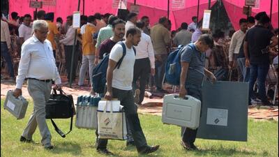 Polling staff carrying EVM machines from the distribution centre at Government College, Panchkula, on Friday for the assembly elections to be held on Saturday. (Sant Arora/HT)