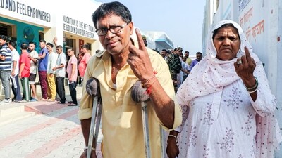 A woman escorts a crutch user as he arrives to cast his vote in Jammu. (ANI) A woman escorts a crutch user as he arrives to cast his vote in Jammu. (ANI)