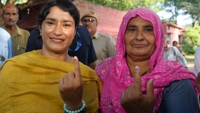Congress candidate from Julana constituency Vinesh Phogat and her family member cast their votes at a polling station at Balali village during the Haryana Assembly elections, in Charkhi Dadri district
 (PTI Photo/Shahbaz Khan) (PTI)