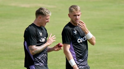 England's Brydon Carse, left, chats with Olly Stone during a practice session, in Multan, Pakistan (AP)