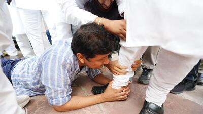 Saurabh Bharadwaj falls at the feet of BJP MLA Vijender Gupta and grabs his foot. (PTI) Saurabh Bharadwaj falls at the feet of BJP MLA Vijender Gupta and grabs his foot. (PTI)