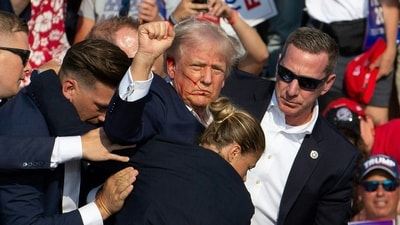 Republican candidate Donald Trump is seen with blood on his face surrounded by Secret Service agents as he is taken off the stage at a campaign event at Butler Farm Show Inc. in Butler, Pennsylvania, July 13, 2024. (Photo by Rebecca DROKE / AFP) Republican candidate Donald Trump is seen with blood on his face surrounded by Secret Service agents as he is taken off the stage at a campaign event at Butler Farm Show Inc. in Butler, Pennsylvania, July 13, 2024. (Photo by Rebecca DROKE / AFP)