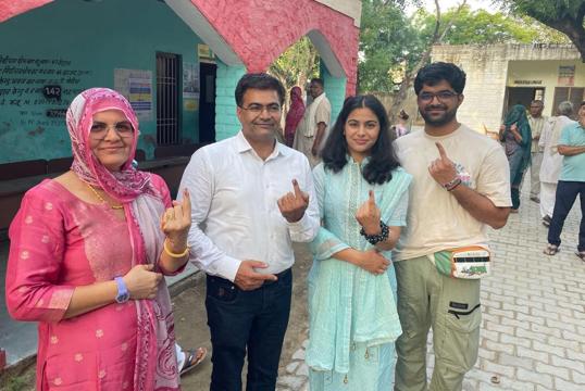 Paris Olympic double-medallist Manu Bhaker with her family after voting at a polling station in Charkhi Dadri on Saturday. (HT Photo)