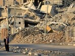 Displaced Palestinians walk past destroyed buildings in al-Bureij refugee camp in the central Gaza Strip. (AFP) Displaced Palestinians walk past destroyed buildings in al-Bureij refugee camp in the central Gaza Strip. (AFP)