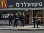 Police officers examine the scene of a stabbing and shooting attack where Israel's Magen David Adom rescue service said one person was killed and several others were wounded in Beersheba, Israel, Sunday, Oct. 6, 2024.