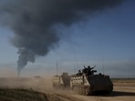 Israeli soldiers move on armored personnel carriers (APC) near the Israeli-Gaza border as smoke rises to the sky in the Gaza Strip. Israeli soldiers move on armored personnel carriers (APC) near the Israeli-Gaza border as smoke rises to the sky in the Gaza Strip.