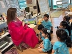One of the photos showed Nita Ambani sitting on a chair and reading a "Peppa Pig" book to the children who are seen smiling One of the photos showed Nita Ambani sitting on a chair and reading a "Peppa Pig" book to the children who are seen smiling
