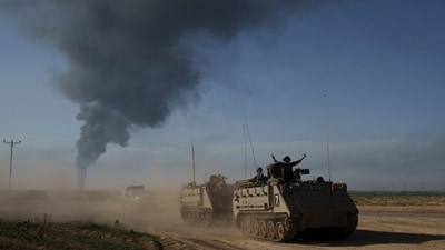 Israeli soldiers move on armored personnel carriers (APC) near the Israeli-Gaza border as smoke rises to the sky in the Gaza Strip. (AP file photo) Israeli soldiers move on armored personnel carriers (APC) near the Israeli-Gaza border as smoke rises to the sky in the Gaza Strip. (AP file photo)