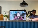 A virtual receptionist at a Bengaluru hotel coordinates with guests via a laptop