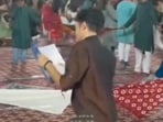 In the video, posted by X user Ankita, a young man dressed in a brown kurta and jeans can be seen matching the dance steps of the garba circle while holding a book in his hands. 