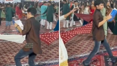 In the video, posted by X user Ankita, a young man dressed in a brown kurta and jeans can be seen matching the dance steps of the garba circle while holding a book in his hands. (X/memeswalimulagi) In the video, posted by X user Ankita, a young man dressed in a brown kurta and jeans can be seen matching the dance steps of the garba circle while holding a book in his hands. (X/memeswalimulagi)