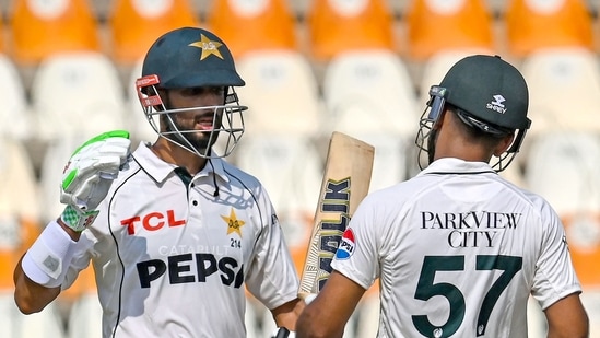 Pakistan's captain Shan Masood celebrates with Abdullah Shafique after scoring a century (100 runs) during the first day of the first Test cricket match between Pakistan and England, at the Multan Cricket Stadium. (AFP)