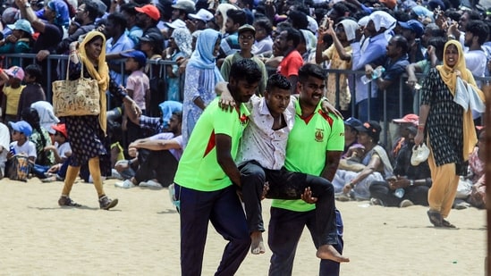 Tamil Nadu Fire and Rescue Service personnel evacuate a man after he fainted due to heat during the Indian Air Force air show.