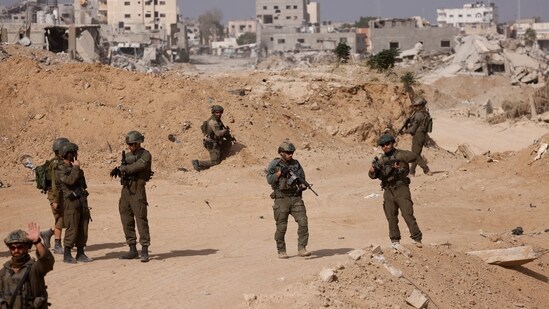 Israel-Iran conflict live updates: Israeli soldiers stand guard as damaged buildings are seen in the background, amid the ongoing war with Hamas and Hezbollah.